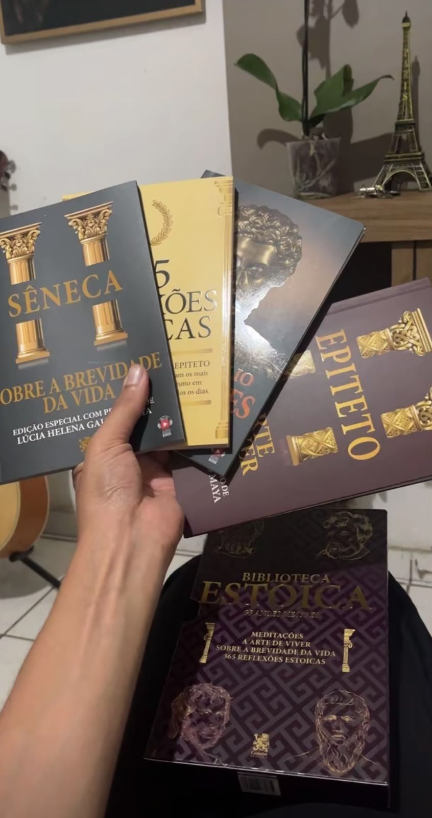 Comprador mostrando os quatro livros da Biblioteca Estoica